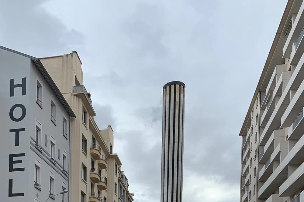 Cheminée de la chaufferie de la Part-Dieu au-dessus des immeubles, à Lyon