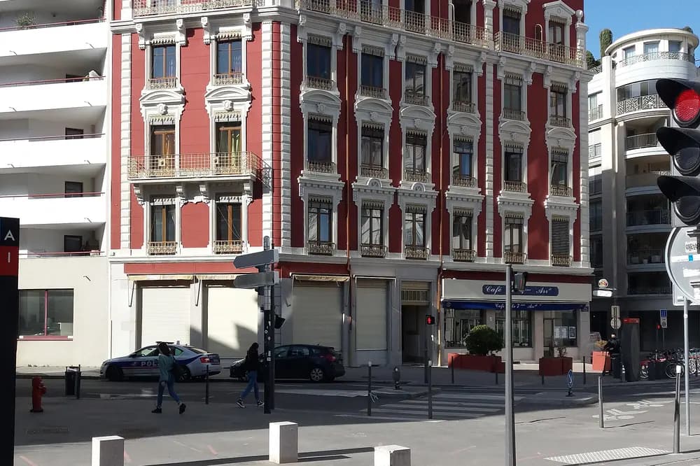 Immeuble d'angle à la façade rouge et blanche, place Jean-Macé à Lyon
